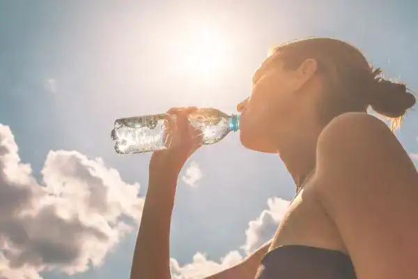Hydration: The Secret Ingredient for a Toned Stomach and Enhanced Fitness 3 Image of woman drinking water to hydrate Trowbridge after run.