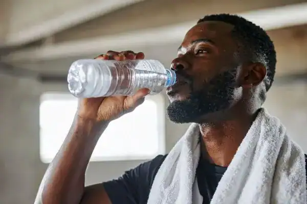 Hydration: The Secret Ingredient for a Toned Stomach and Enhanced Fitness 1 Image of man drinking water to improve hydration Trowbridge after work out.